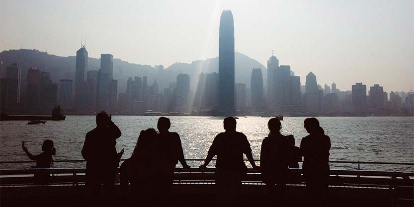 behind view of young people looking across the sea 