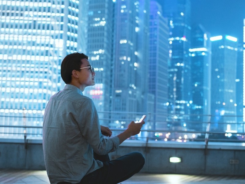 office employee sitting on roof and chatting on phone