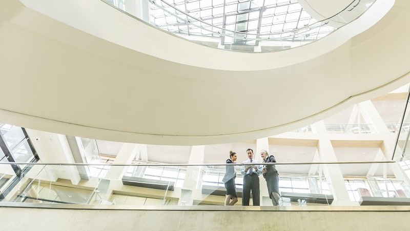 Three corporate professionals having an informal meeting in modern office