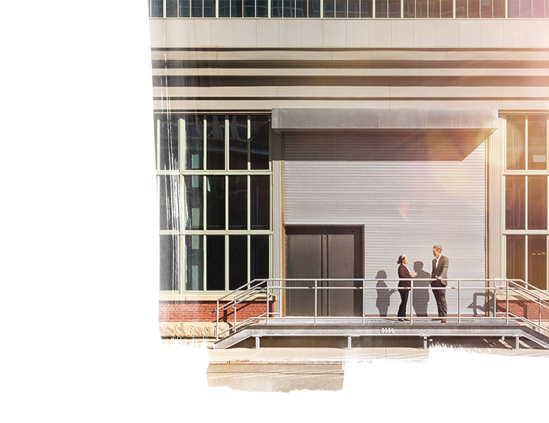 Men and a women speaking at the entrance of the building