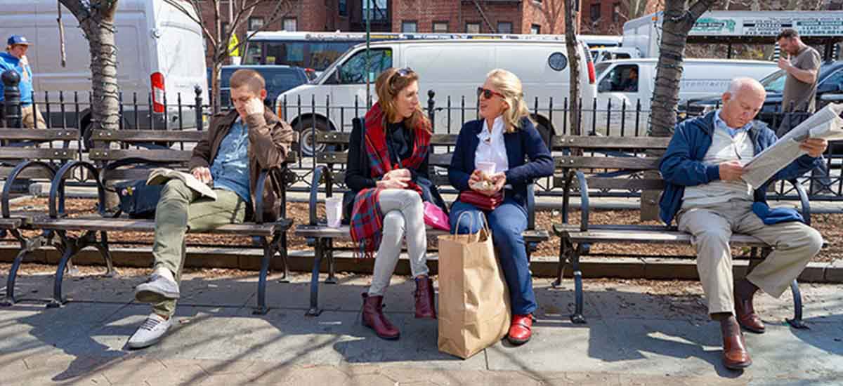 Two woman sitting on a bench and talking about Real estate transparency