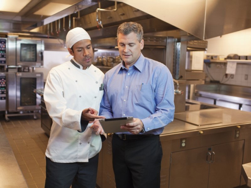 Chef and manager discussing something in the kitchen