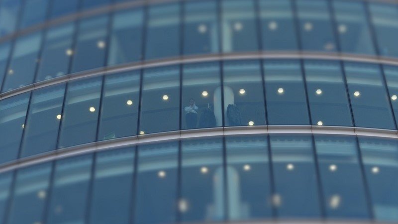 Person watching through the glass building 