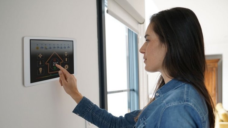 A woman maintaining the room temperature by using smart home technology