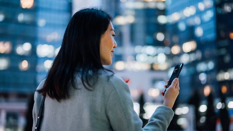 A woman standing and looking mobile