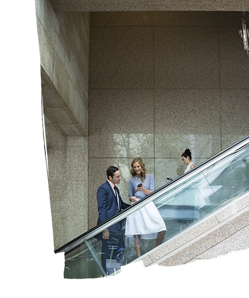 Two employees having a conversation while looking at the phone and climbing the stairs