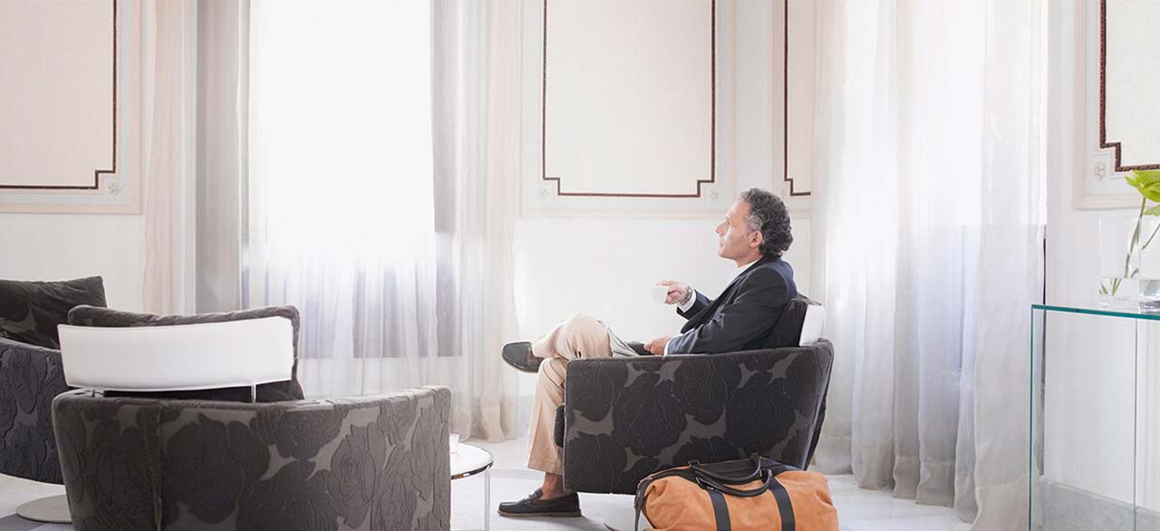 Man enjoying espresso in a modern hotel suite