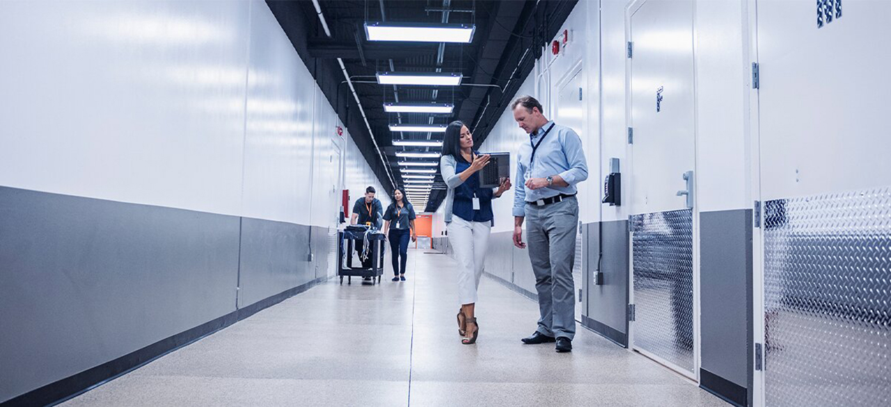 Two colleagues discussing something at the corridor of the data center