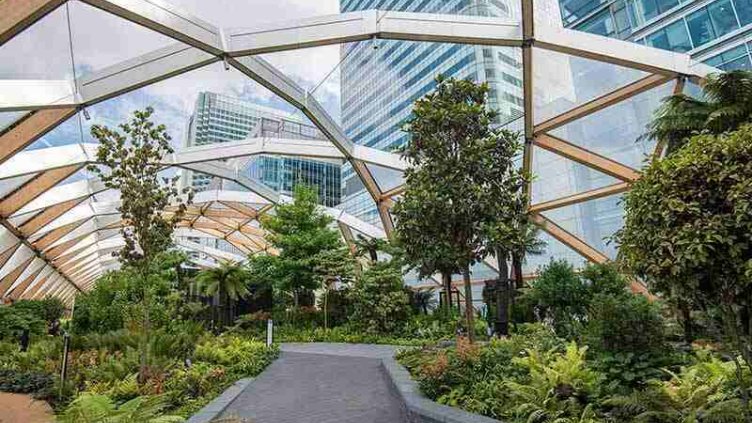 real estate glass covered pathway having greenery at both end committed to emmission reduction